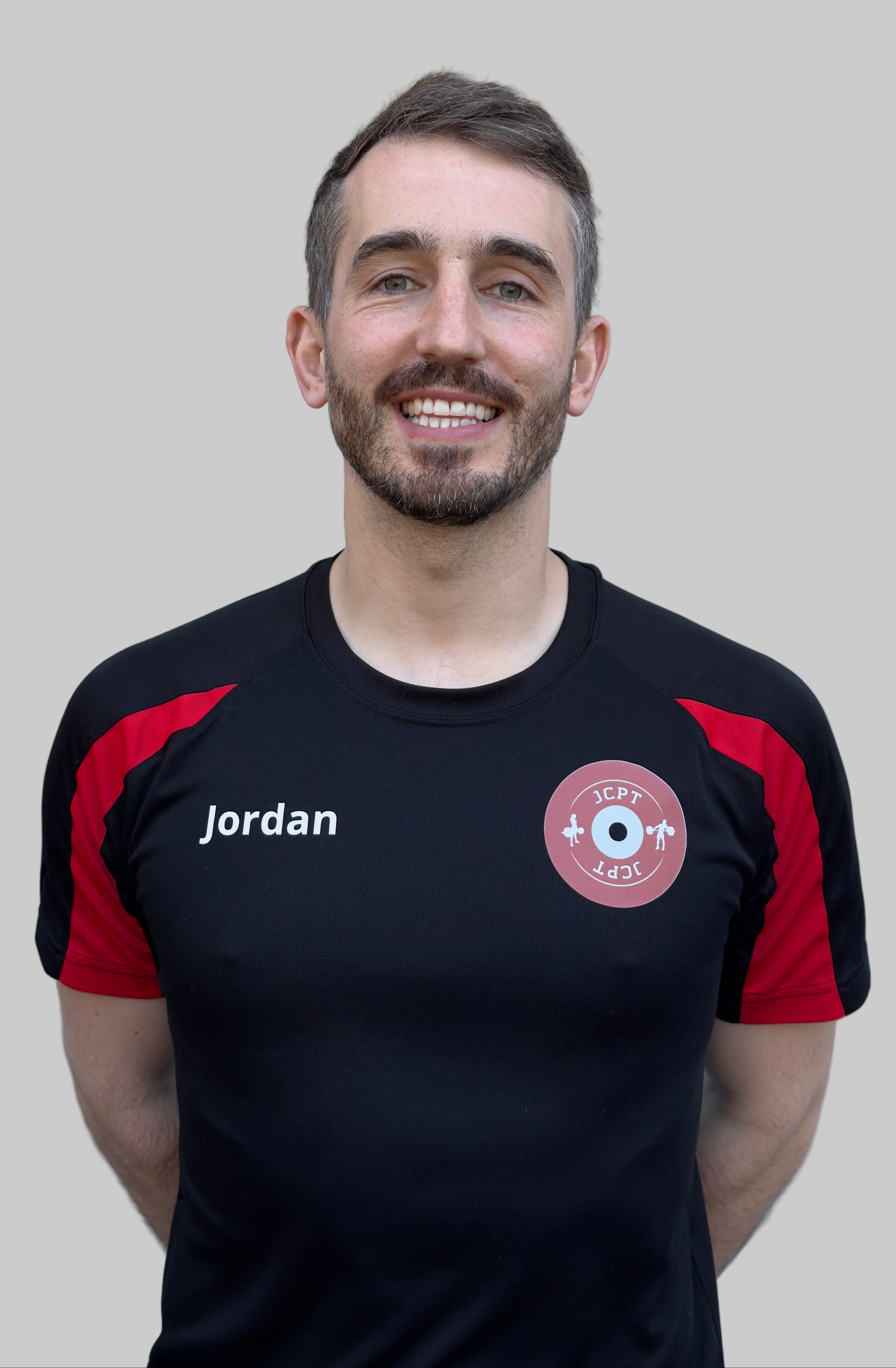 Man wearing a black and red sports jersey with 'Jordan' branding against a plain background